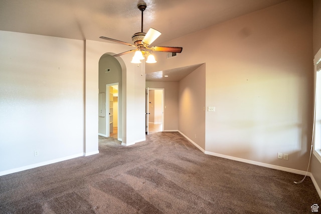 unfurnished room with a ceiling fan, carpet flooring, baseboards, and arched walkways
