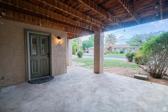property entrance with stucco siding and a patio