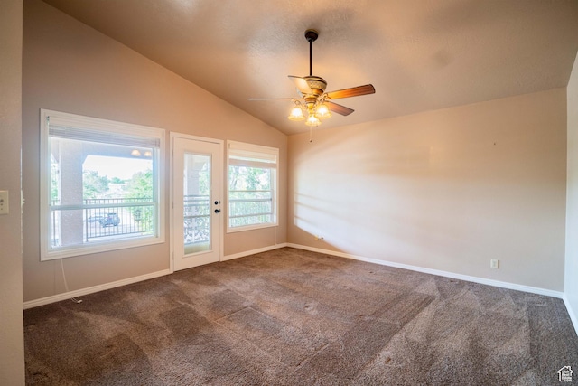 carpeted empty room with lofted ceiling, a ceiling fan, and baseboards