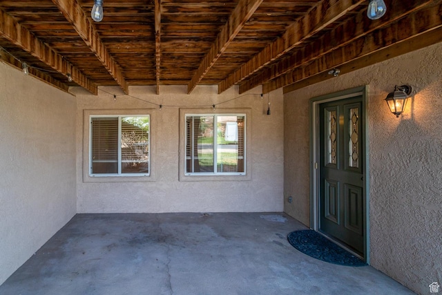 doorway to property featuring stucco siding and a patio area
