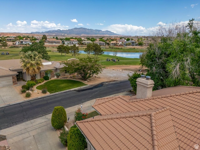 view of community featuring a water and mountain view, a residential view, and a yard