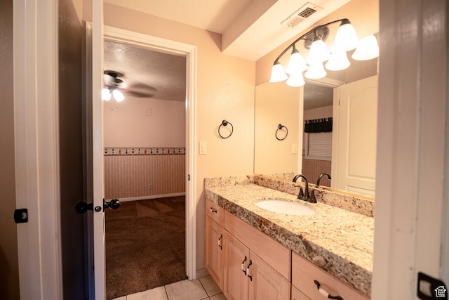 bathroom featuring tile patterned floors, vanity, ceiling fan, and a textured ceiling
