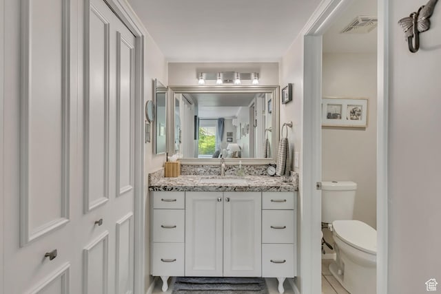 bathroom featuring toilet, vanity, and tile patterned floors
