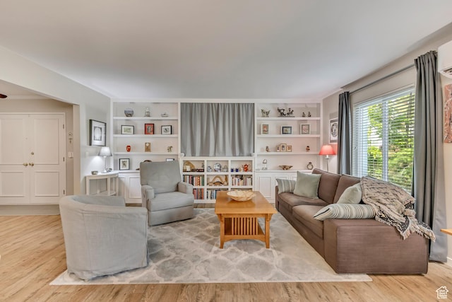 living room with wood finished floors and built in shelves
