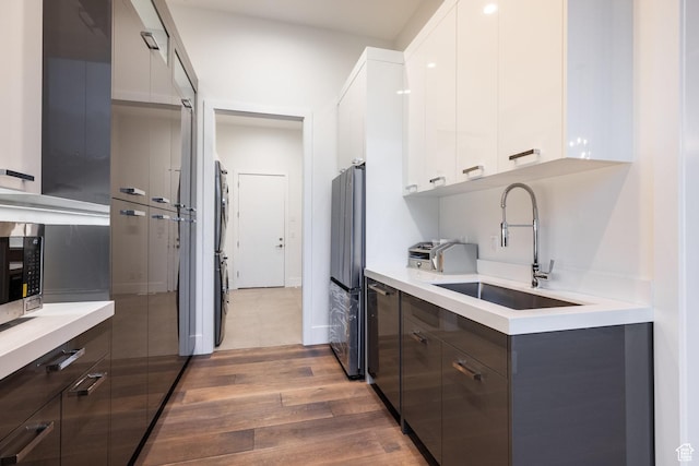 9969 S Altamont Dr E, Sandy, UT 84092 - kitchen with modern cabinets, wood finished floors, a sink, and light countertops