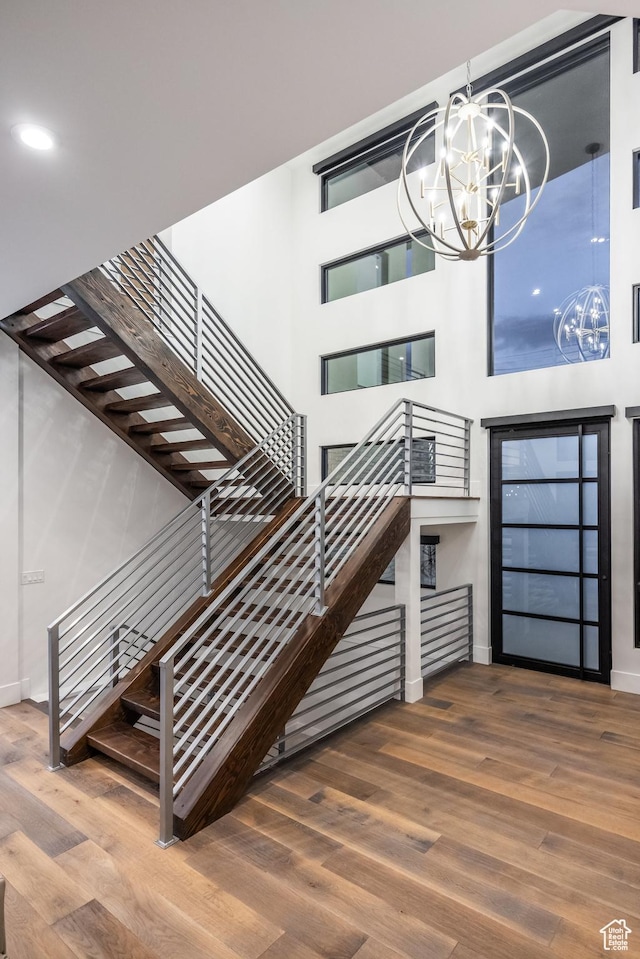 9969 S Altamont Dr E, Sandy, UT 84092 - stairs featuring a chandelier, wood finished floors, baseboards, and a high ceiling
