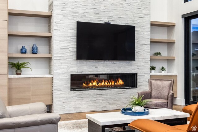 9969 S Altamont Dr E, Sandy, UT 84092 - living room with wood finished floors, built in features, and a stone fireplace