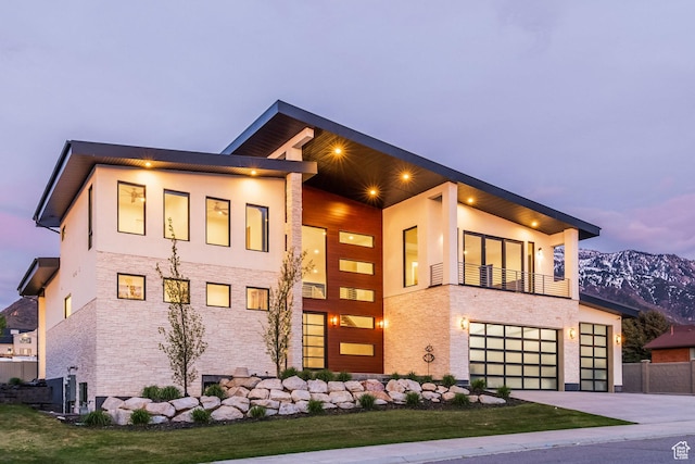 9969 S Altamont Dr E, Sandy, UT 84092 - view of front of property featuring stone siding, a garage, a mountain view, stucco siding, and driveway