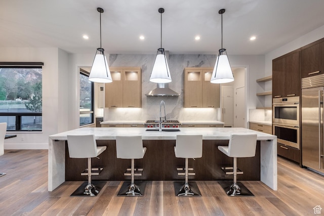9969 S Altamont Dr E, Sandy, UT 84092 - kitchen featuring appliances with stainless steel finishes, open shelves, a large island with sink, recessed lighting, and light wood-type flooring