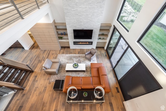 9969 S Altamont Dr E, Sandy, UT 84092 - living area featuring a high ceiling, wood-type flooring, and a stone fireplace
