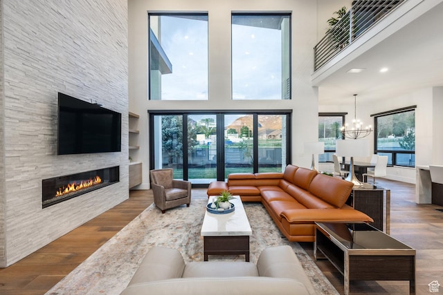 9969 S Altamont Dr E, Sandy, UT 84092 - living room featuring wood finished floors, a fireplace, a chandelier, and a high ceiling