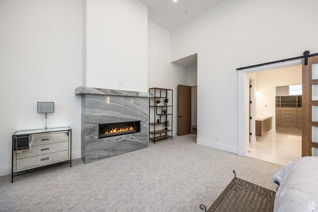 9969 S Altamont Dr E, Sandy, UT 84092 - bedroom with carpet flooring, a premium fireplace, baseboards, a towering ceiling, and a barn door