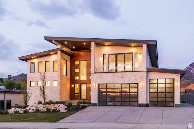 9969 S Altamont Dr E, Sandy, UT 84092 - modern home with driveway, a balcony, stone siding, and stucco siding