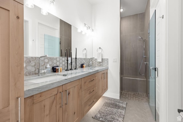 bathroom featuring tiled shower, tasteful backsplash, double vanity, tile patterned flooring, and baseboards