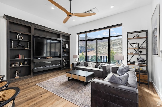 living room featuring wood finished floors, a ceiling fan, and recessed lighting