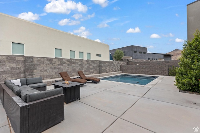 view of pool featuring a patio area, a fenced backyard, and an outdoor living space with a fire pit
