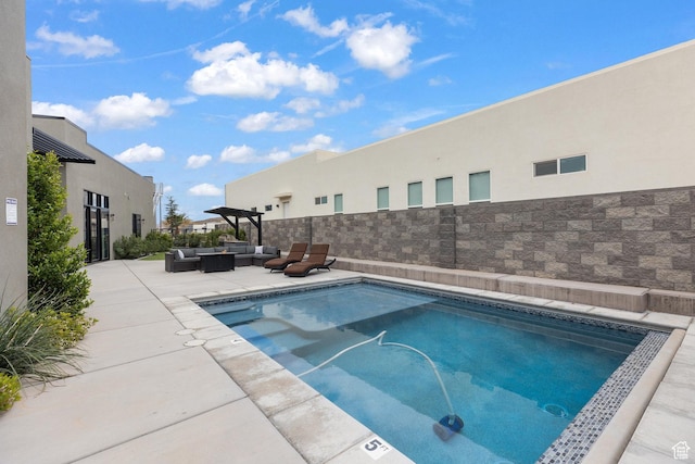 view of pool featuring outdoor lounge area and a patio