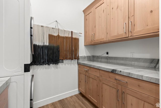 laundry room featuring light wood-style floors and baseboards