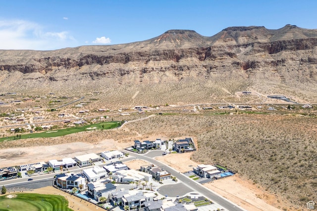 aerial view of property's location with a mountain backdrop, nearby suburban area, a local golf course, and a desert landscape