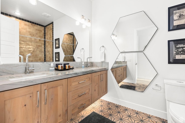 bathroom featuring toilet and double vanity