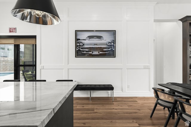 dining area featuring a decorative wall, wood finished floors, and a chandelier