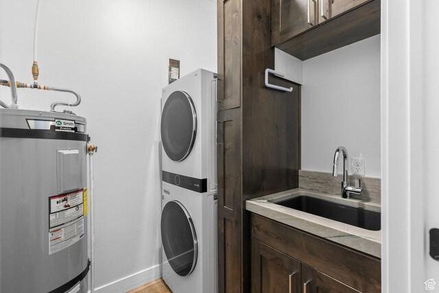 1450 W Torrey Pines Rd, Hurricane, UT 84737 - laundry area with water heater, stacked washer / drying machine, cabinet space, and light wood-style floors