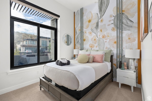 bedroom with light colored carpet and baseboards