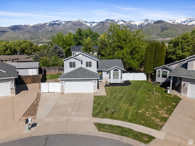 view of front of property featuring a garage, a mountain view, driveway, stone siding, and roof with shingles