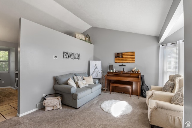 living area featuring lofted ceiling, carpet flooring, and baseboards