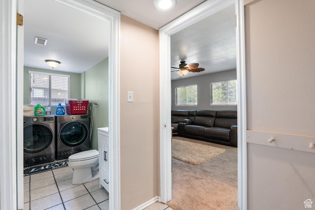 bathroom with washing machine and dryer, a ceiling fan, tile patterned flooring, and toilet