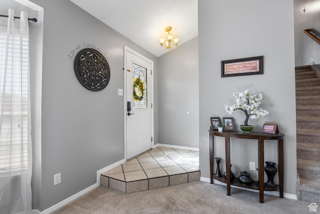 carpeted entryway with stairway, a chandelier, lofted ceiling, and baseboards