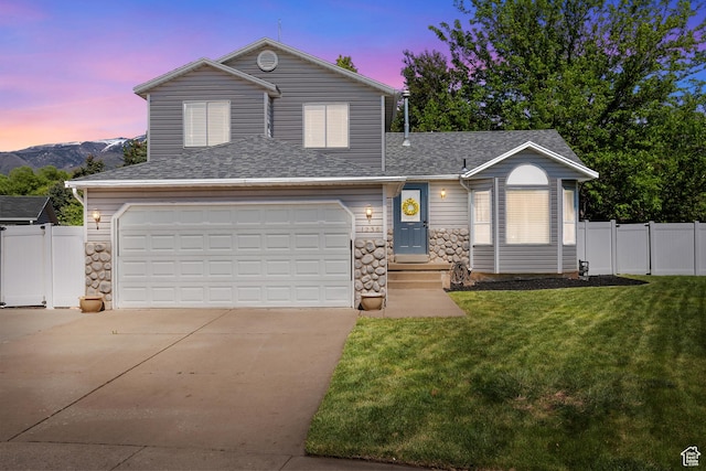 traditional-style house with concrete driveway, an attached garage, roof with shingles, and stone siding