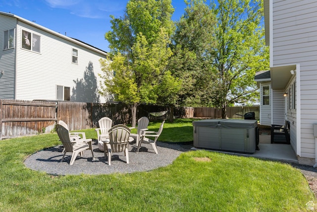 view of yard featuring a hot tub, a patio, and an outdoor fire pit
