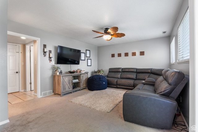 living room featuring light colored carpet, a ceiling fan, baseboards, and light tile patterned floors
