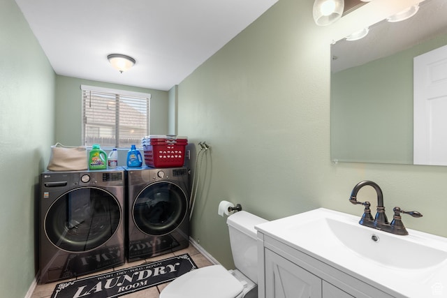 clothes washing area featuring independent washer and dryer, a sink, baseboards, and light tile patterned floors