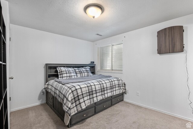 bedroom with a textured ceiling, carpet, and baseboards
