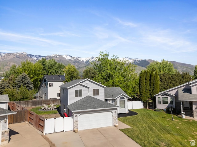 view of front of property featuring concrete driveway, a mountain view, an attached garage, a gate, and roof with shingles