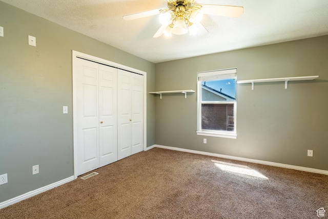 unfurnished bedroom with carpet, a closet, baseboards, and a ceiling fan