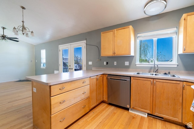 kitchen with dishwasher, a sink, a peninsula, light wood finished floors, and french doors