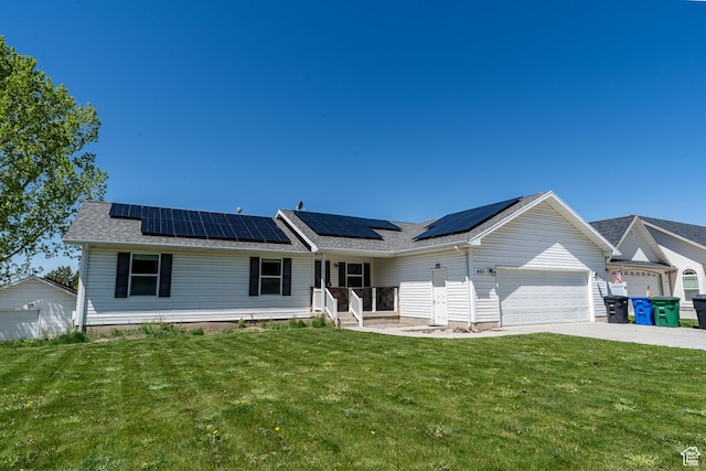 single story home with a garage, a front lawn, concrete driveway, and roof mounted solar panels
