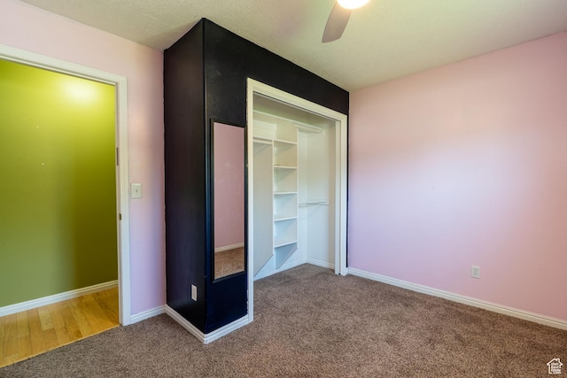 unfurnished bedroom with carpet flooring, a closet, baseboards, and a ceiling fan
