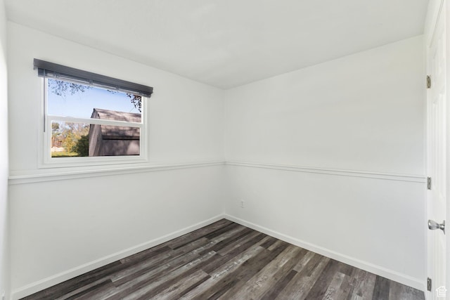 empty room with dark wood-type flooring and baseboards