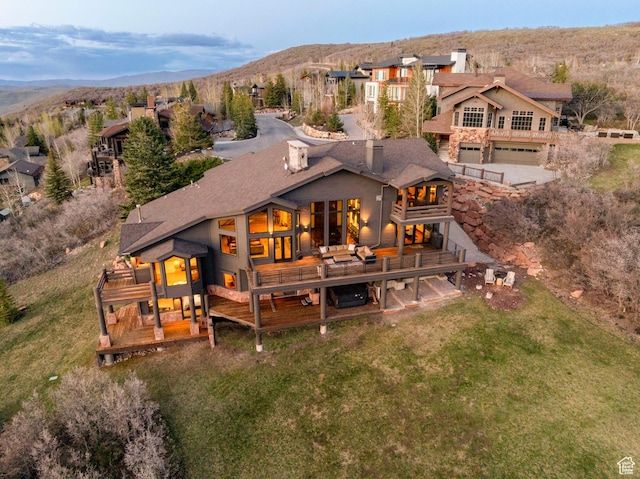 3623 Oakwood Ct, Park City, UT 84060 - rear view of house with a deck with mountain view, an attached garage, and a lawn