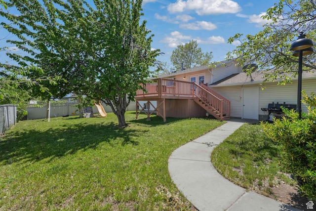 view of yard featuring stairway, a wooden deck, and a playground