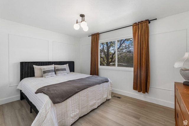bedroom with light wood finished floors and baseboards