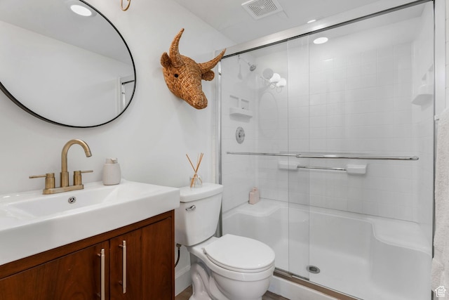 full bath featuring toilet, a shower stall, and vanity