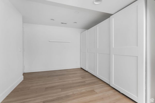 bonus room with light wood-style floors
