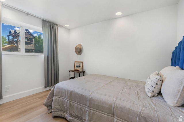 bedroom with wood finished floors, recessed lighting, and baseboards