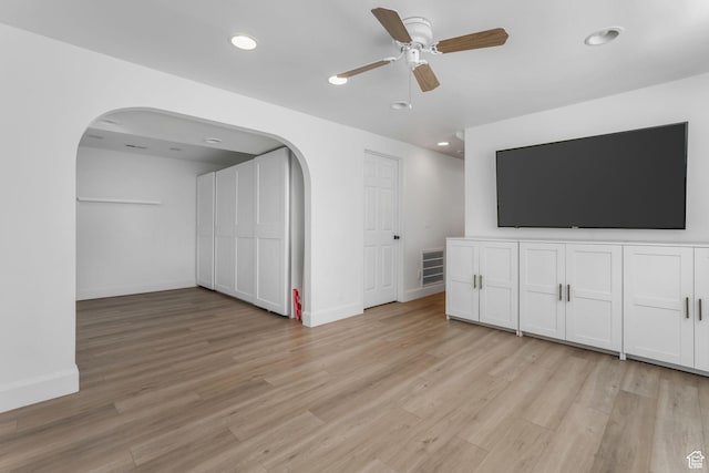 unfurnished living room with arched walkways, light wood-style floors, ceiling fan, and recessed lighting