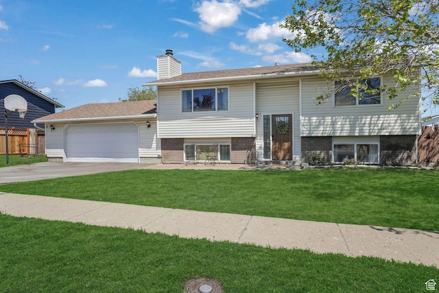 split foyer home with a chimney, driveway, a garage, and brick siding